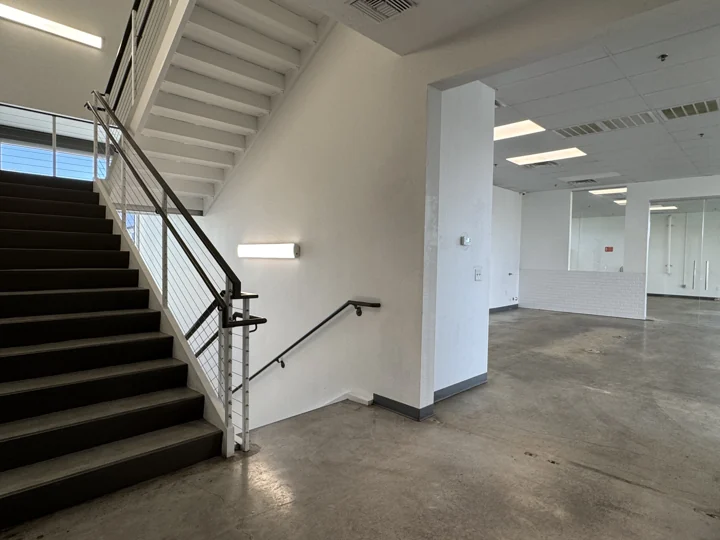 Interior stair beside glass-partitioned rooms