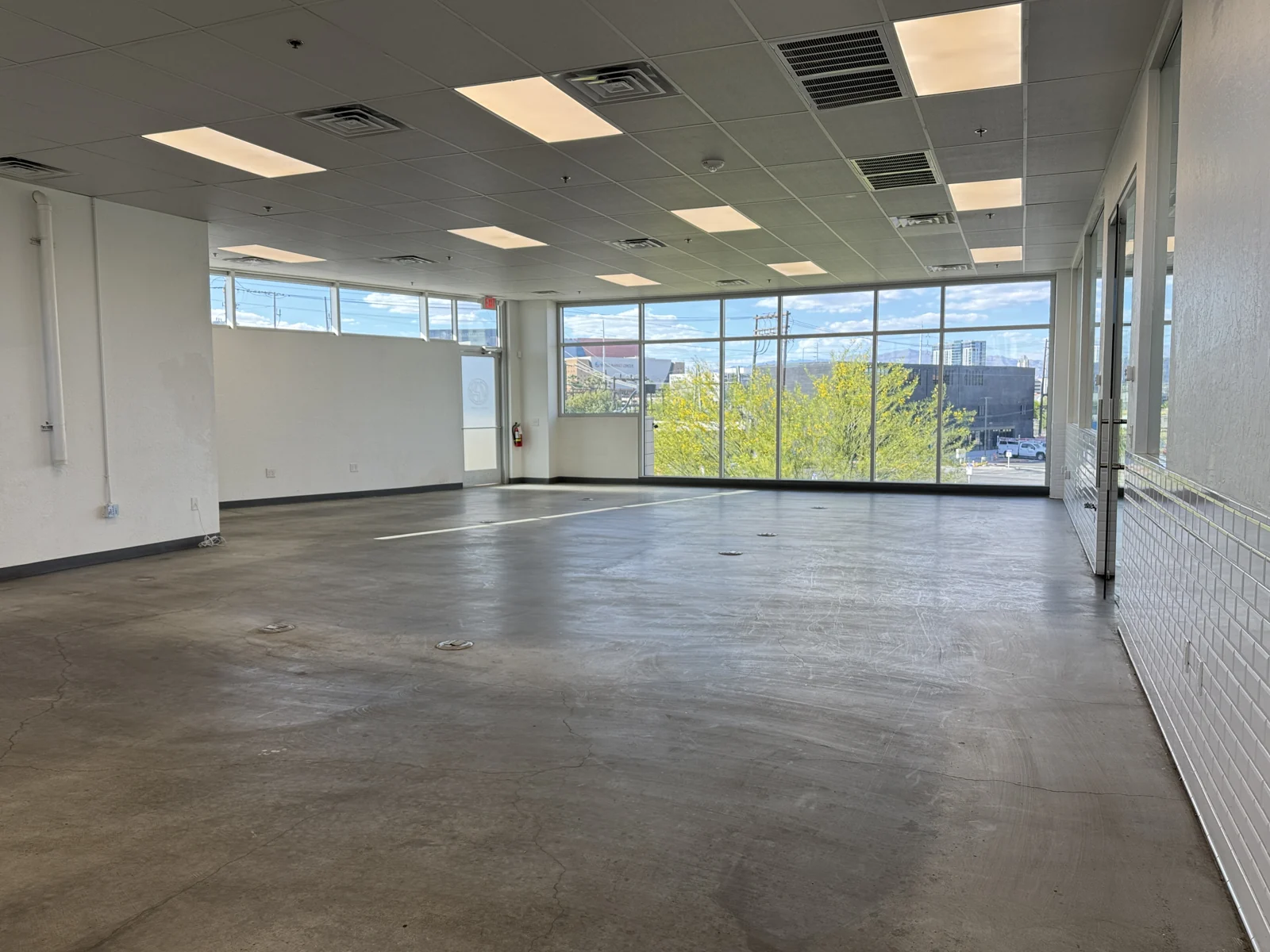 Open interior with polished concrete floors, glass partitions and a wall of windows