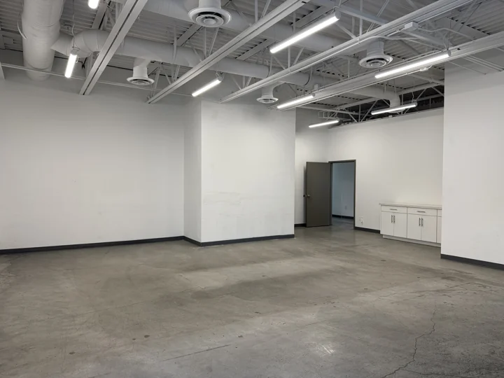 Open empty room with concrete floors and exposed ceiling